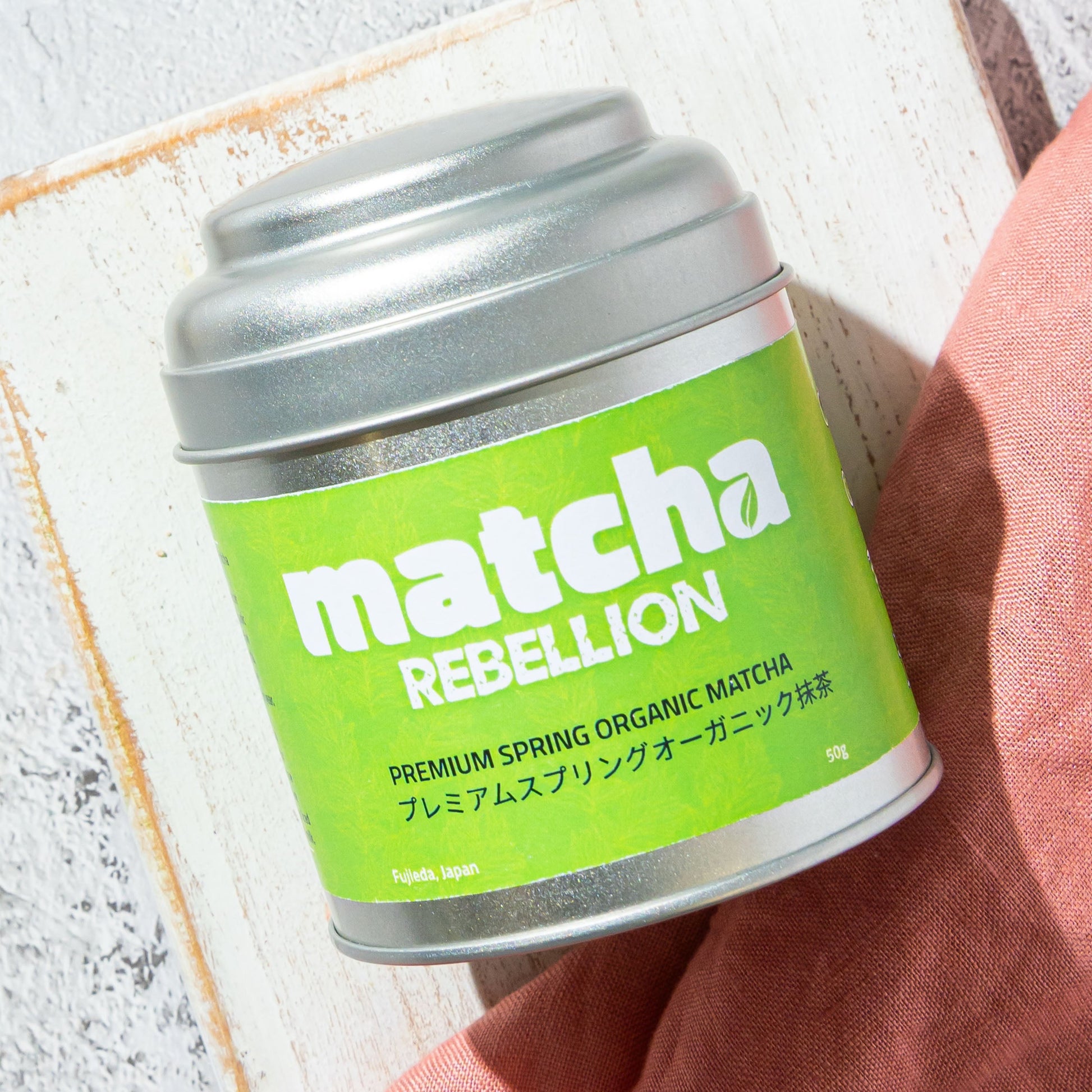 Tea Rebellion matcha product on a light gray surface .